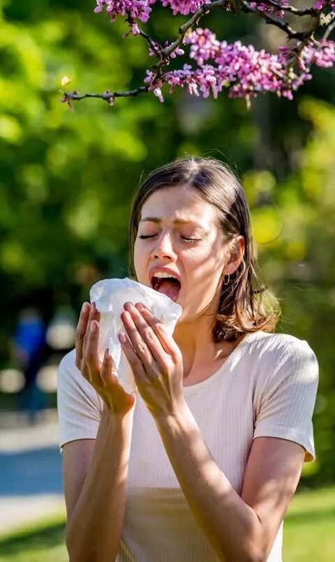 Girl sneezing due to allergies, highlighting the need for effective allergy removal treatment.